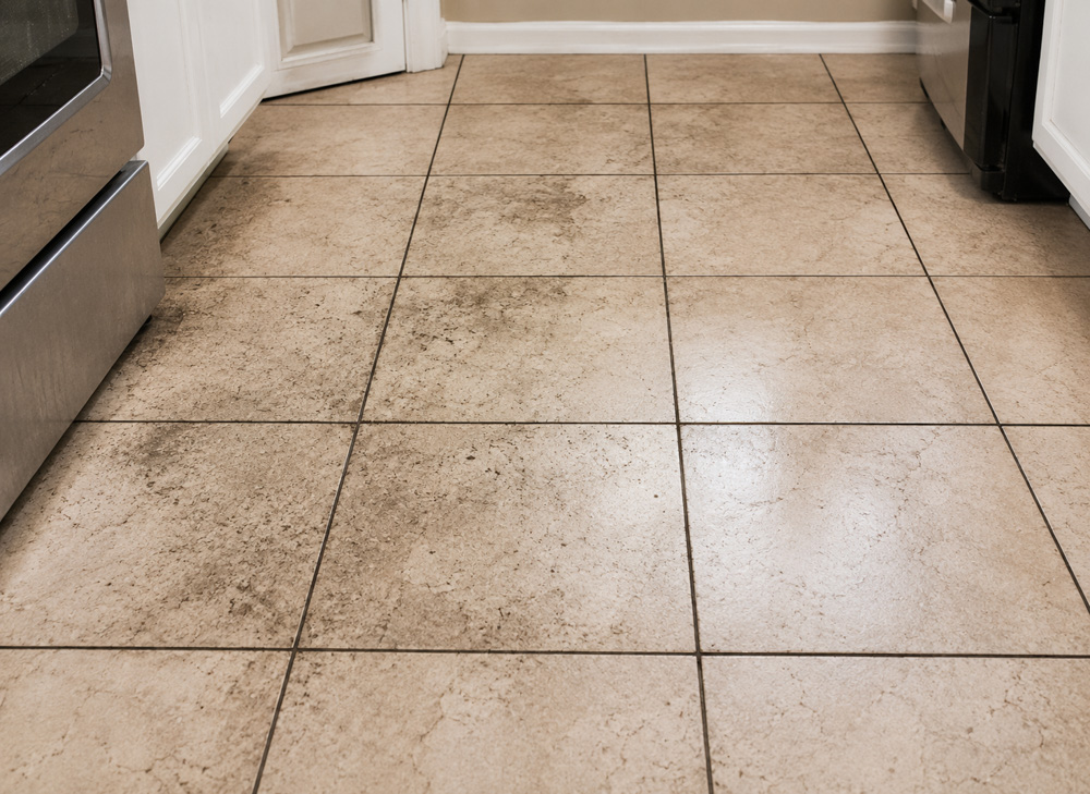 Kitchen floor tile and grout before restoration in Altamonte Springs, FL